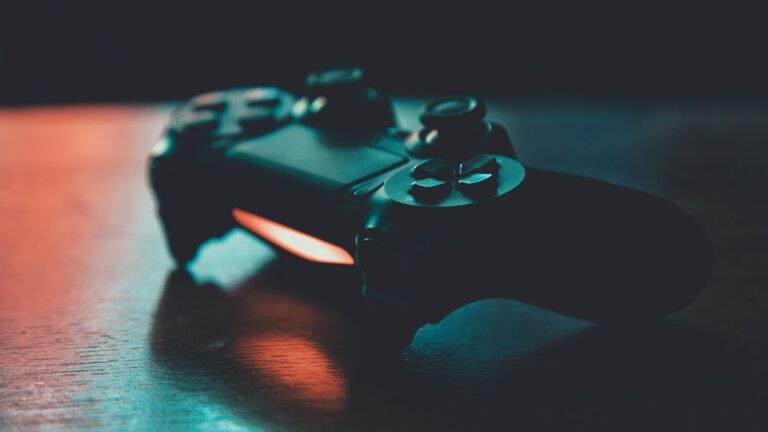 Manette de jeu noire sur une surface en bois sous un éclairage bleu et orange