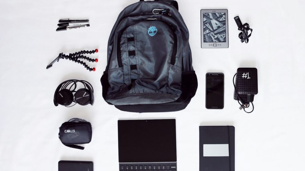 Sac à dos, ordinateur portable, casque, smartphone et trépied vus du dessus