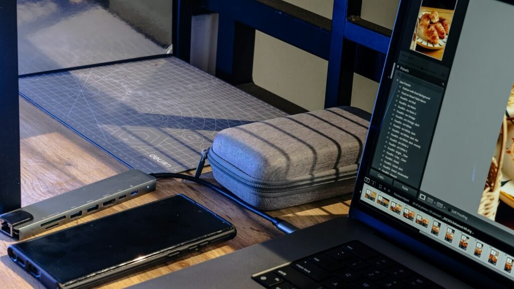 Ordinateur portable, téléphone et hub USB sur un bureau en bois