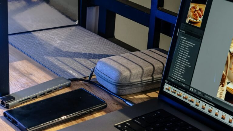 Ordinateur portable, téléphone et hub USB sur un bureau en bois
