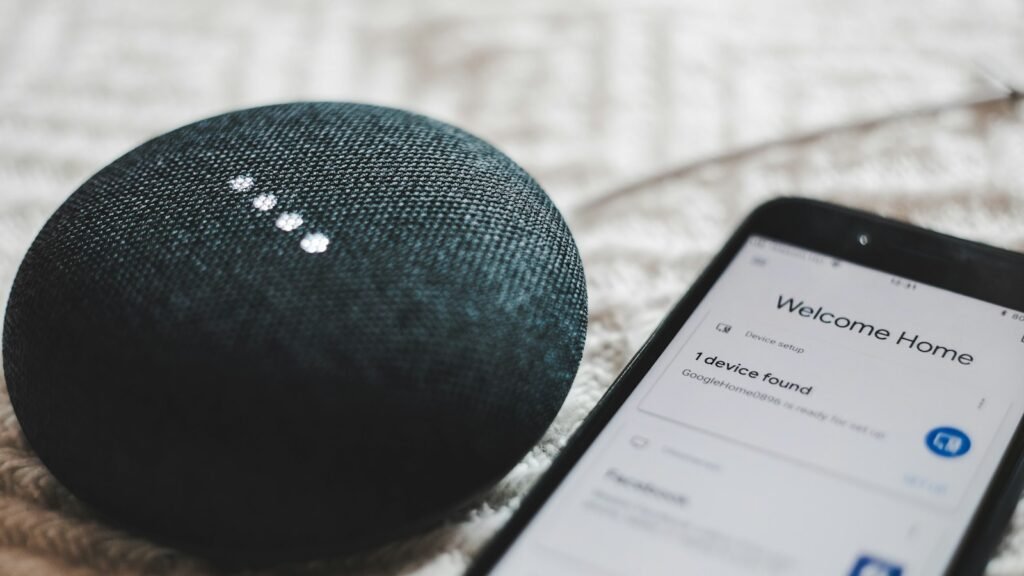 Enceinte connectée allumée à côté d'un smartphone